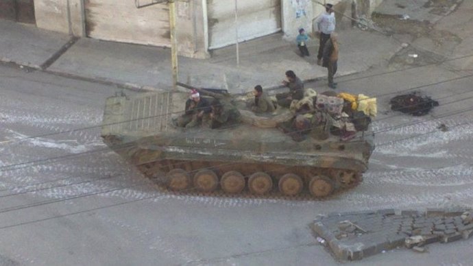 Militares sirios patrullando en un carro de combate