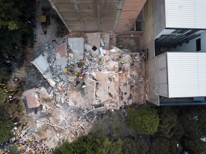 Search and rescue operations are carried out at the site of a collapsed building