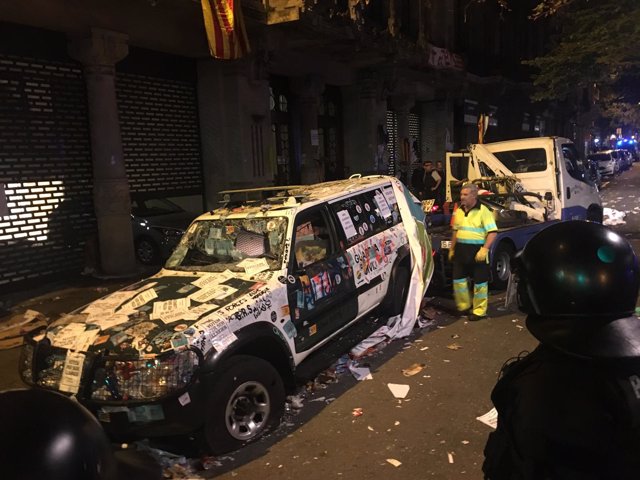 Una grúa retira un coche destrozado de la Guardia Civil en Barcelona