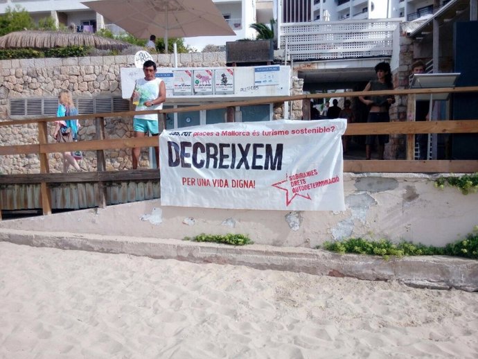 Pancarta en la playa de Cala Major contra la masificación turísitica