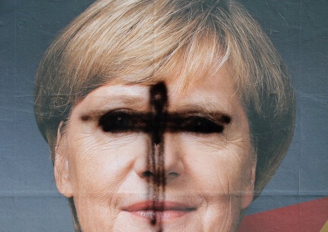 Cartel mutilado de la canciller alemana Angela Merkel