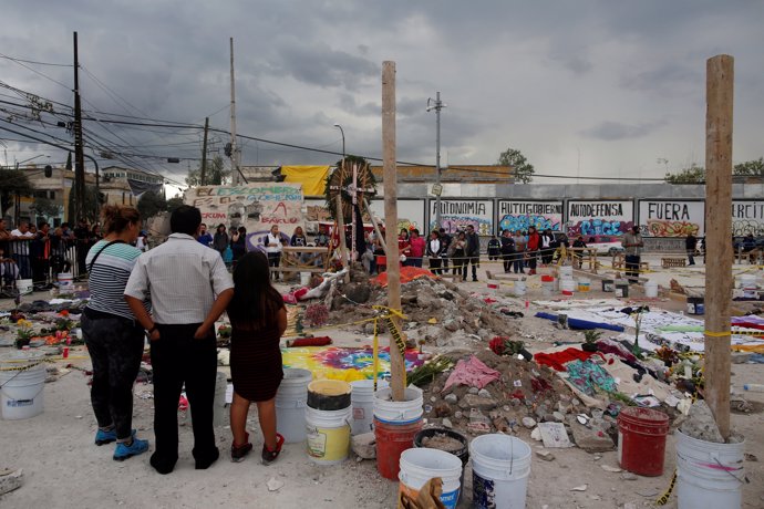 Residents pray for victims at a makeshift altar, in an area that used to be a te