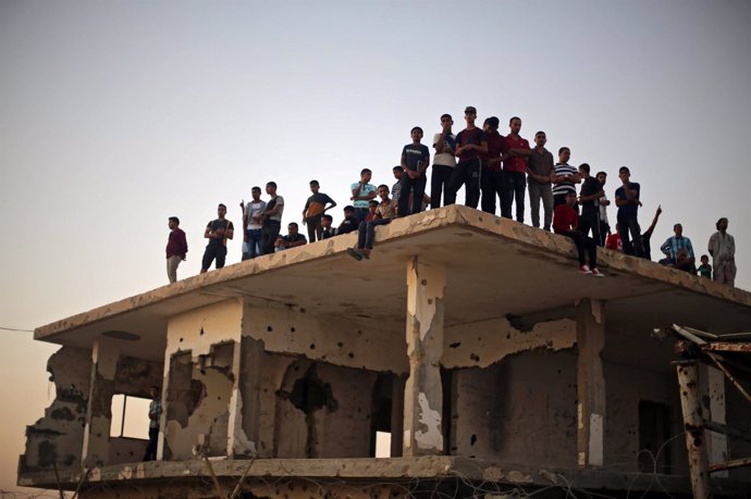 Personas sobre un edificio en el paso de Rafá, en el sur de la Franja de Gaza
