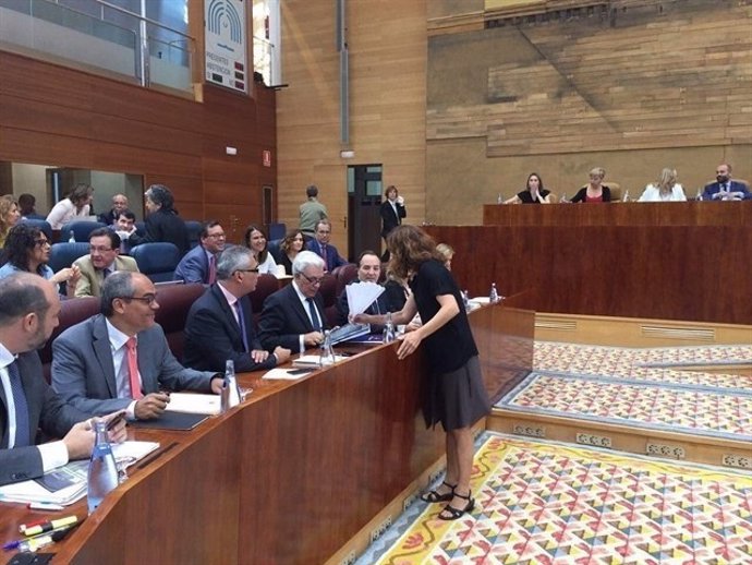 Diputada de Podemos, Mónoca García, entrega un abanico de papel al Consejero 