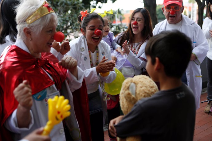 Members of the Doctor Clown AC group entertain a child who lost his home in an e