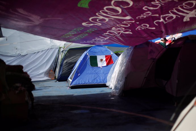 A Mexican flag is seen on a tent in a provincial campsite on a basketball court 