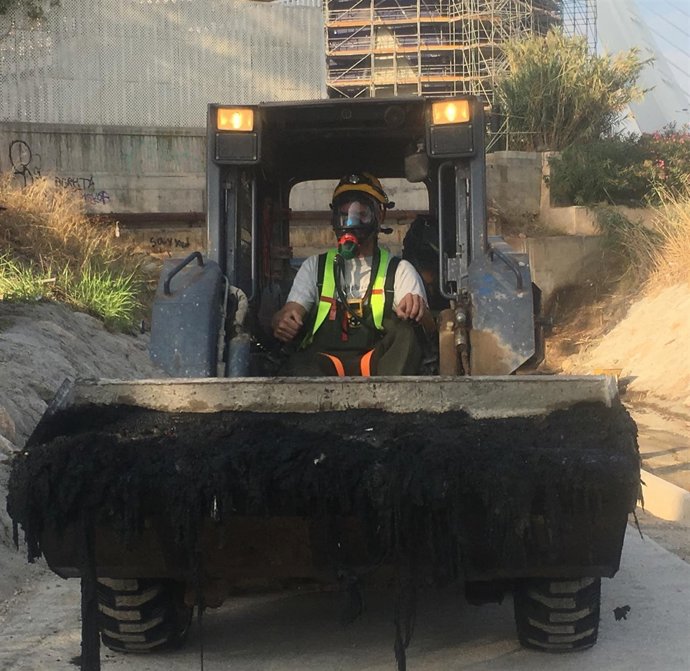 Técnico cargando toallitas del Colector Norte con una excavadora