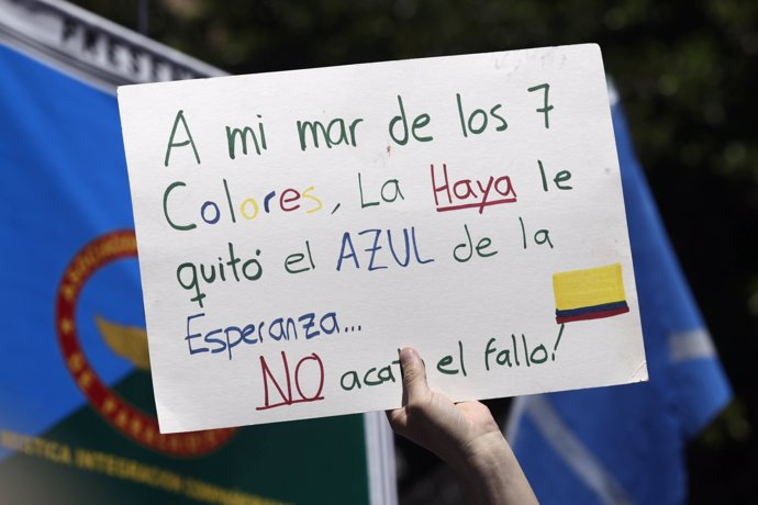A Colombian holds up a sign which reads, "The Haya took the blue hope from my se