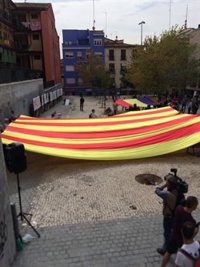 Una gran señera se despliega en Lavapiés a favor del referéndum catalán bajo el lema 'Urnas son amores'