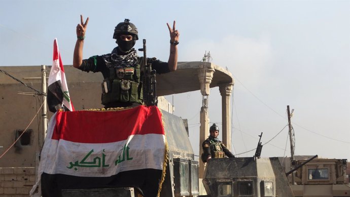 Un miembro de las fuerzas de seguridad iraquíes con la bandera en Ramadi
