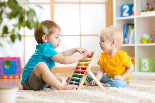 Dos niños juegan con un ábaco.
