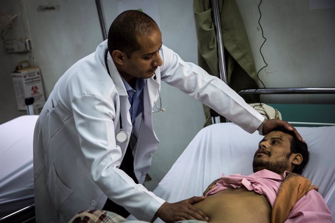 Un médico atiende a un paciente en un hospital yemení