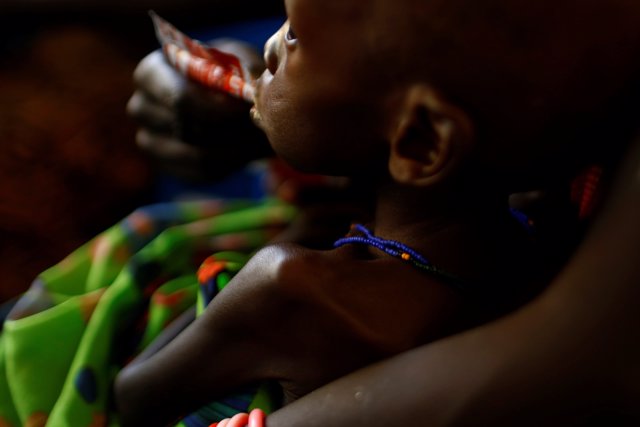 Una madre alimenta a su hijo con una barrita nutritiva en Sudán del Sur 