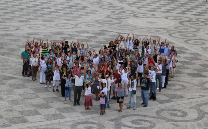 Cientos de personas forman un corazón humano en la Plaza de España