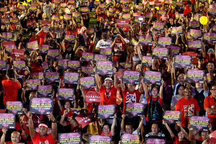Manifestantes malasios con pancartas "Ama Malasia, derriba la cleptocracia"