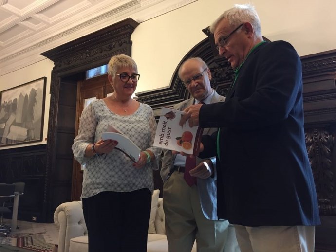 El alcalde Joan Ribó ojea la guía visual de la AVL 'Amb molt de gust'