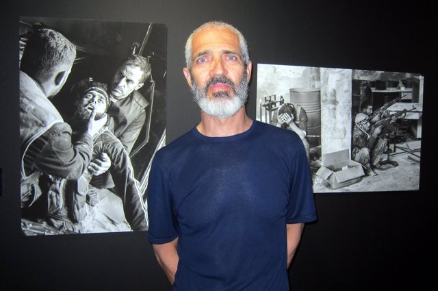 El fotógrafo Alberto Prieto delante de imágenes suyas en la exposición