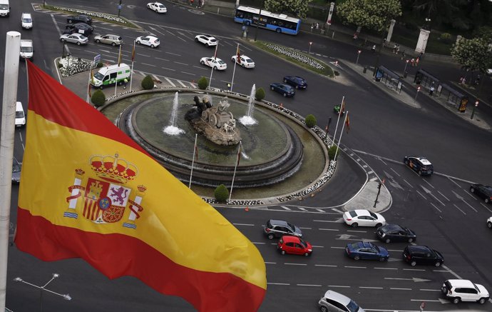 A Spanish flag flutters above the Cibeles fountain as they are seen from observa