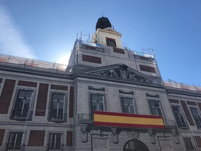 El reloj de la Puerta del Sol recubierto con una lona decorativa con su imagen