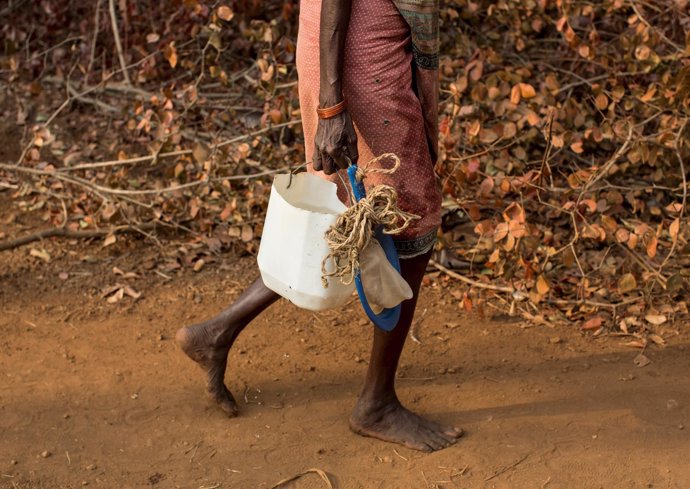 Una mujer transporta agua en una zona rural de India