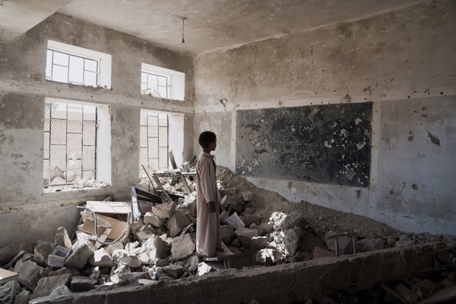 Un estudiante en las ruinas de una escuela en Yemen