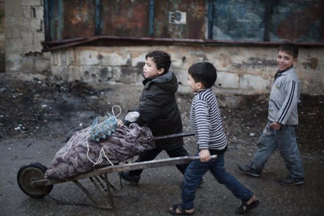 Niños empujan un carro en Ghuta Oriental, cerca de Damasco