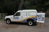 Una decena de participantes del programa 'Palma Xapa i Mecànica II' reparan un vehículo de la Policía Montada