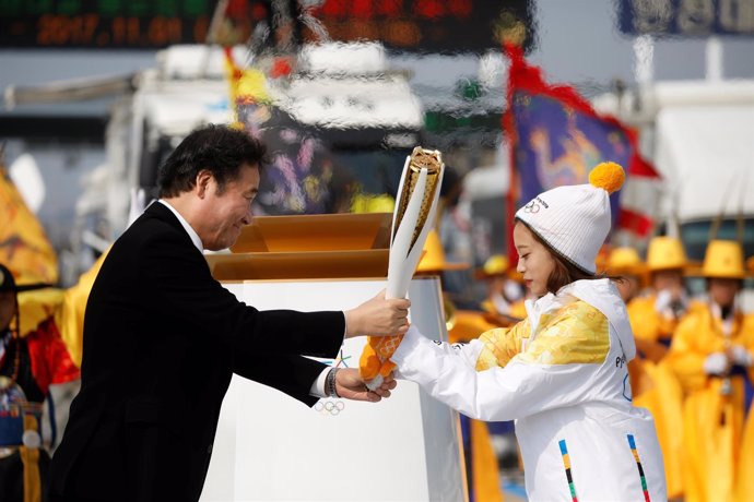Nak-yeon Lee entrega la llama olímpica a la joven Young Yu