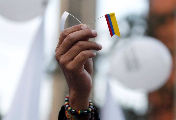 A supporter rallying for the nation’s new peace agreement with FARC holds a tiny