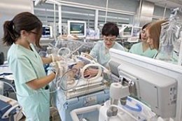 Profesionales del equipo de Neonatología trabajando en una incubadora.