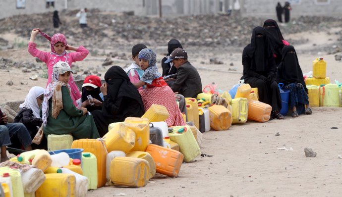 Personas esperan para recoger agua en Saná, Yemen.