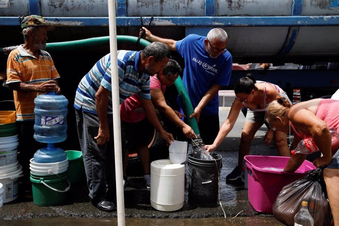 Puertorriqueños esperan para obtener agua tras el paso del huracán. 