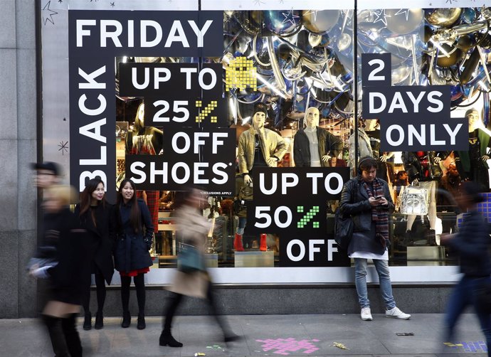 Shoppers walk past a store promoting "Black Friday" in London, Britain November 