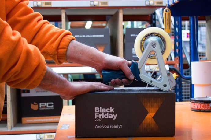 Un empleado de PcComponentes precinta una caja con motivo del 'Black Friday'