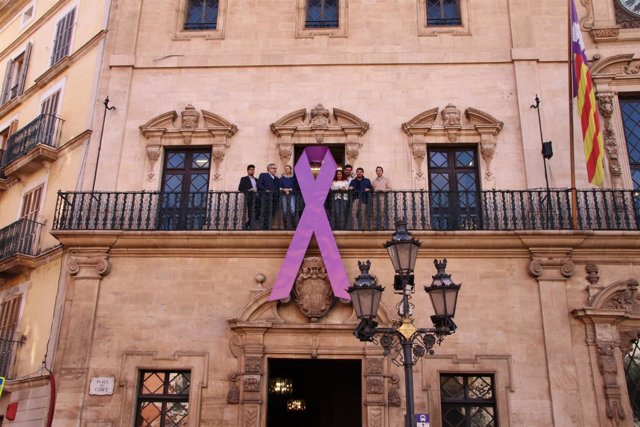 La fachada de Cort ya muestra el lazo morado contra la violencia hacia las mujeres