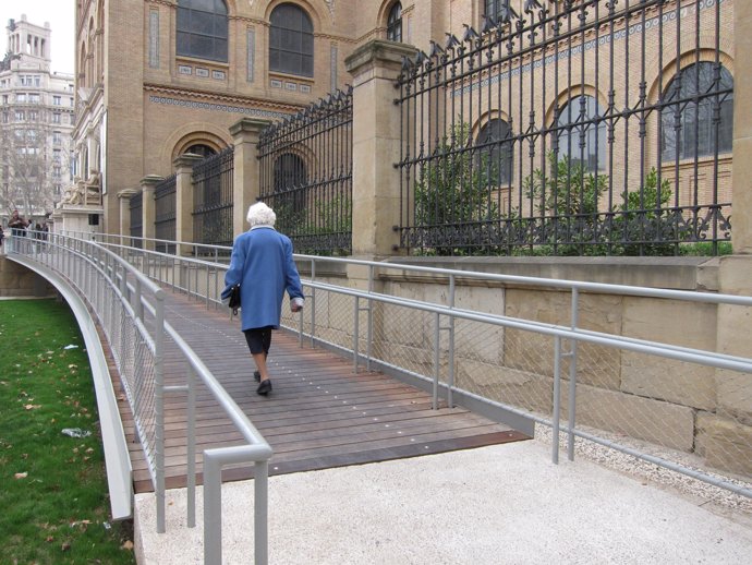 Una persona mayor camina por la rampa accesible del Paraninfo