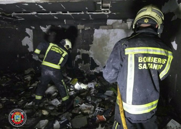 Bomberos trabajan en la extinción del incendio. En la imagen se aprecian libros