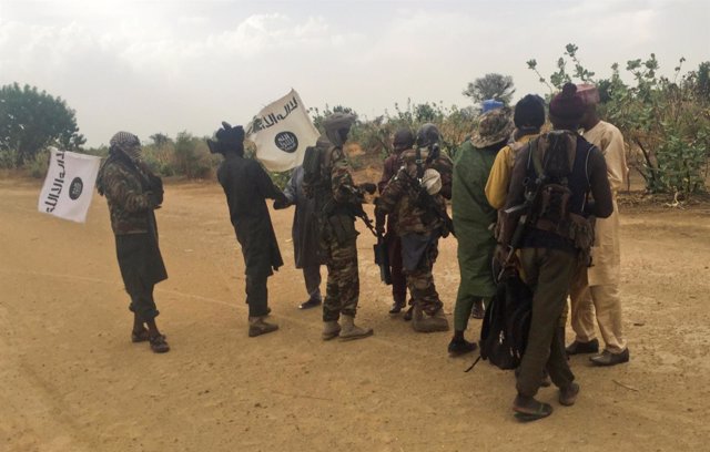 Boko Haram militants (in camouflage) embrace and shake hands 