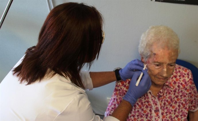Una enfermera aplicando el tratamiento con luz