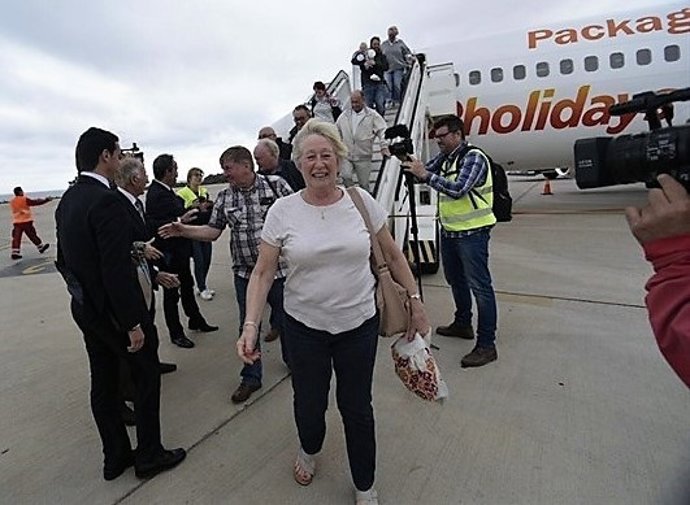 Turistas bajando de avión en aeropuerto