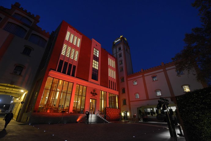 Façana de l'Antiga Fàbrica Estel Damm il·luminada de vermell