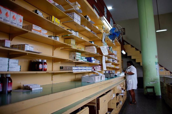 La empleada de una farmacia cubana habla por teléfono en La Habana