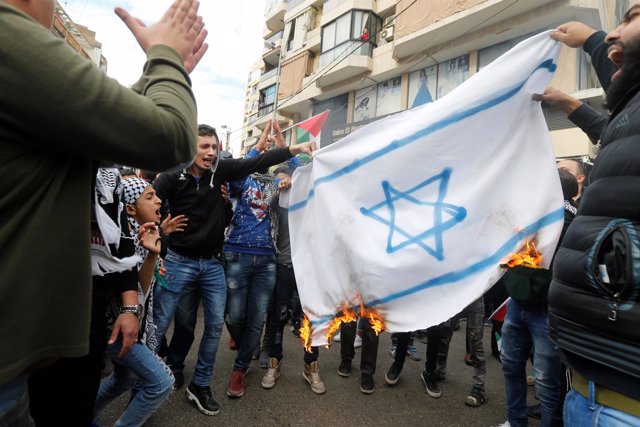 Manifestantes contra la decisión de Trump en Beirut queman una bandera israelí