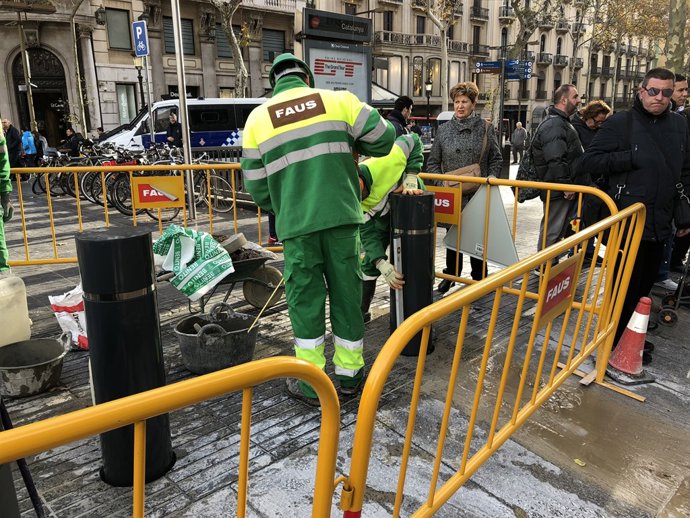 Un operari instal·la pilons a la part superior de la Rambla
