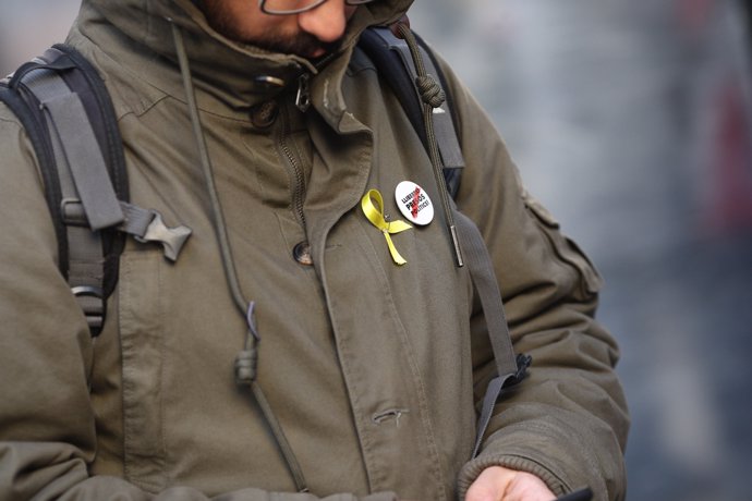 Una persona amb llaç groc i xapa de llibertat per als presos polítics