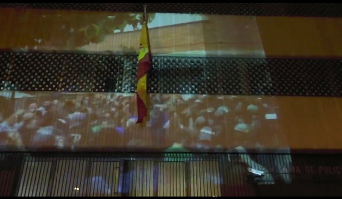 Una manifestació projecta imatges de l'1-O en una comissaria