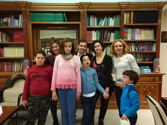 López (centro), recibe a los niños en la delegación