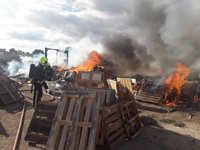 Los bomberos trabajan en la extinción de un incendio en unos palés en el camino viejo de Elche en Alicante