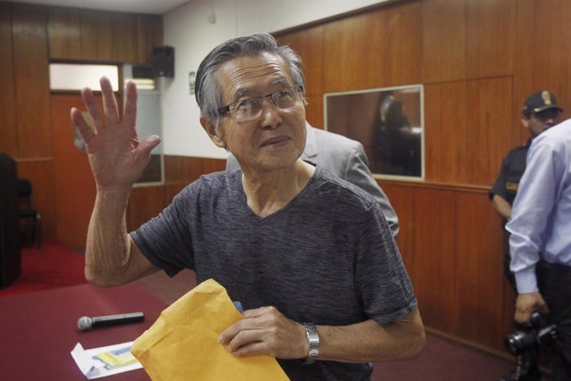 Peru's former President Alberto Fujimori waves to the media as he arrives in cou