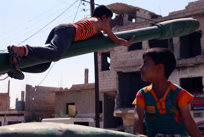 Niños jugando con restos de armamento en Deraa